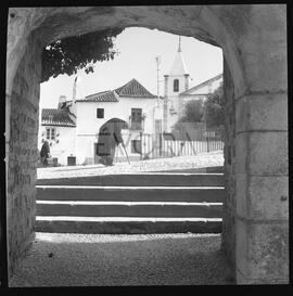 Velhota a passar em frente a uma porta do Castelo